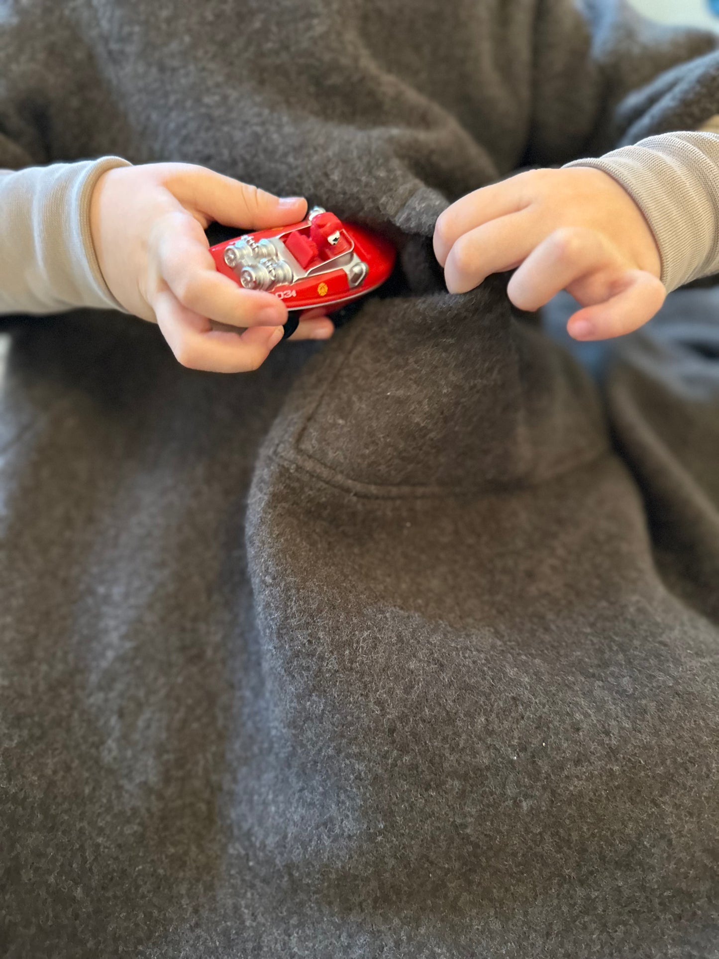 Detailaufnahme der Merinodecke, natürlicher Merinowollfleece, mit kleiner Tasche für Lieblingsspielzeug